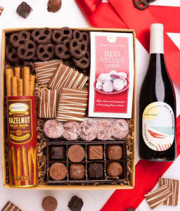 A gift box with chocolate pretzels, chocolate graham crackers, red velvet cookies, hazelnut wafer rolls, an 8 piece box of chocolates and a Season's Greeting message card.